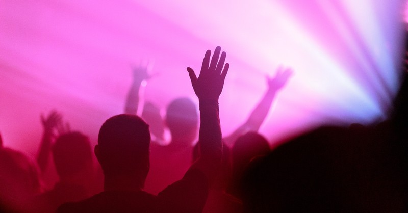 A crowd with hands raised in worship