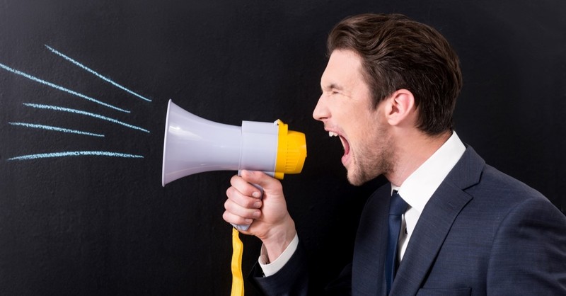 man yelling through bullhorn