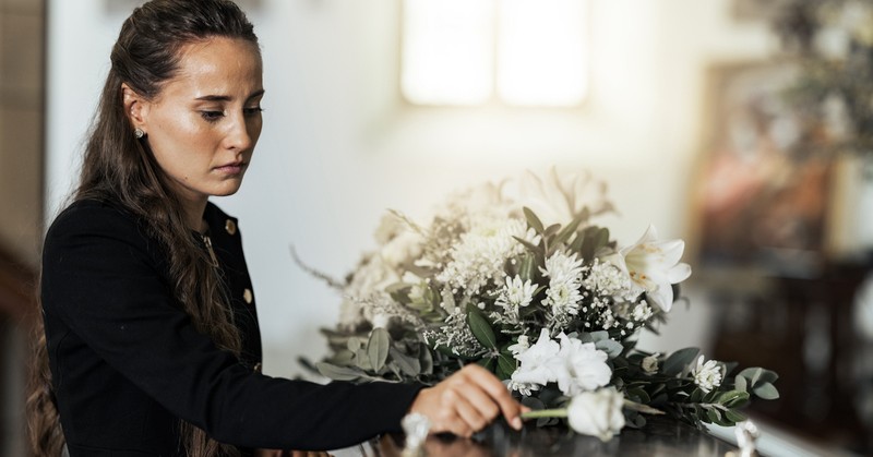 Sad widow woman crying at funeral grieving death