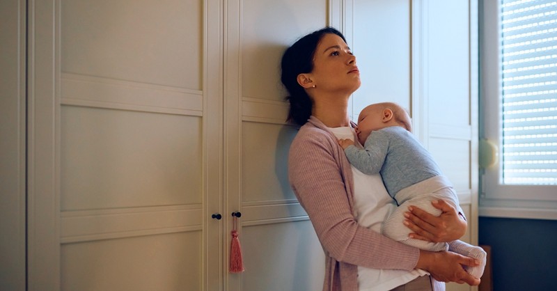 Mom looking tired holding her baby