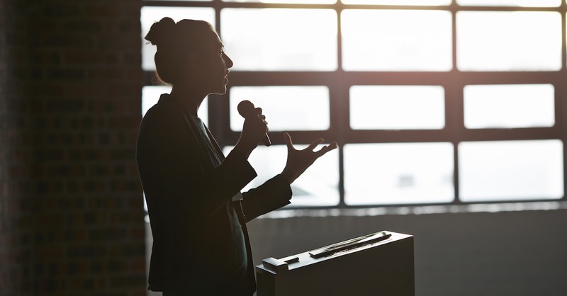 woman speaking at podium with microphone