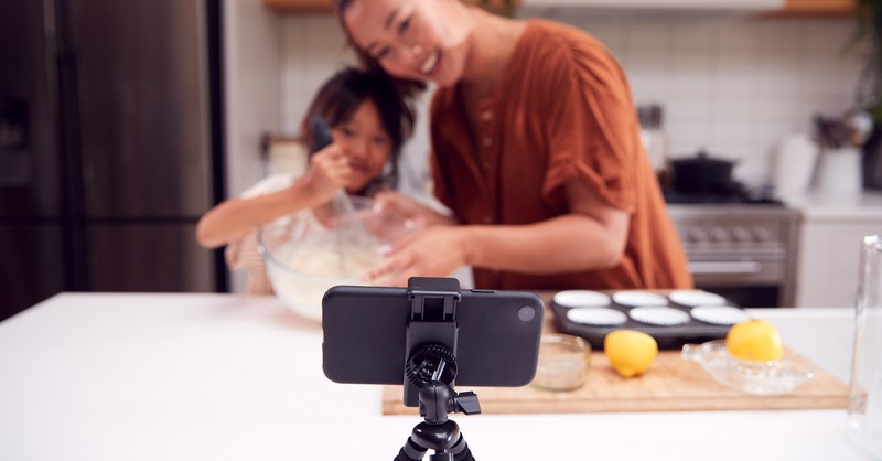 Mom and daughter vlogging recording with camera in kitchen