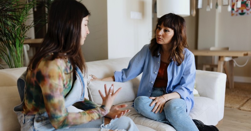 Adult daughter teen with toxic mom talking on couch upset