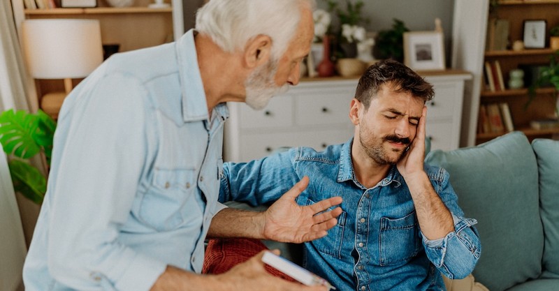 Upset toxic adult parent arguing with son on couch