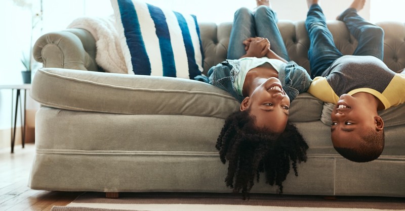 laughing kids brother and sister playing siblings on couch