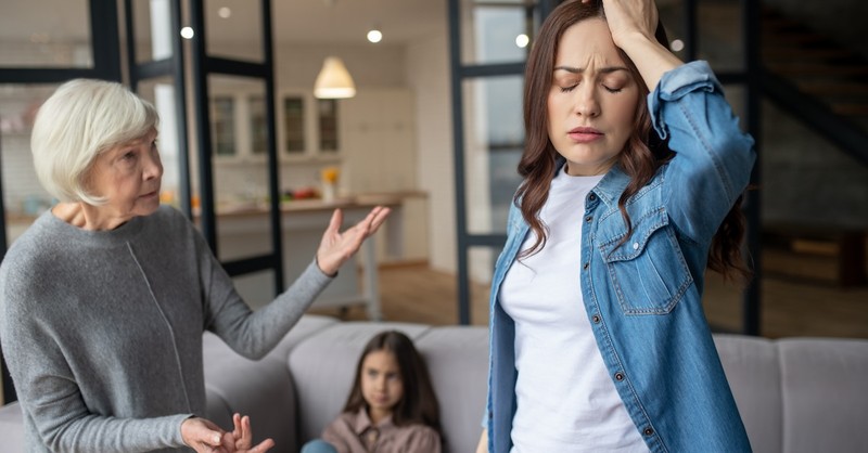 Grandmother and adult daughter arguing in front of grandchild