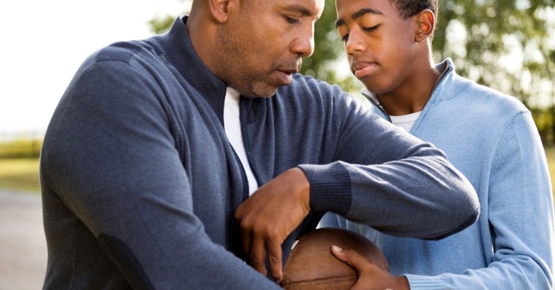 father and son playing with football