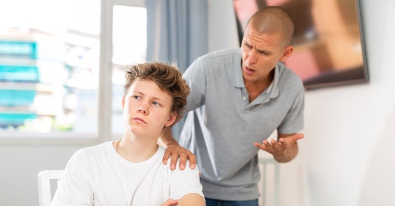 angry father shouting at apathetic son, how to handle teenage behavior