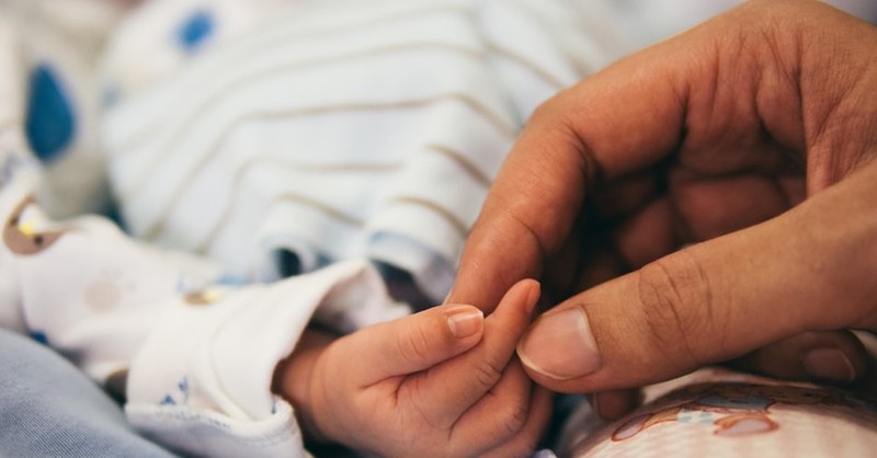 mom holding baby's hand