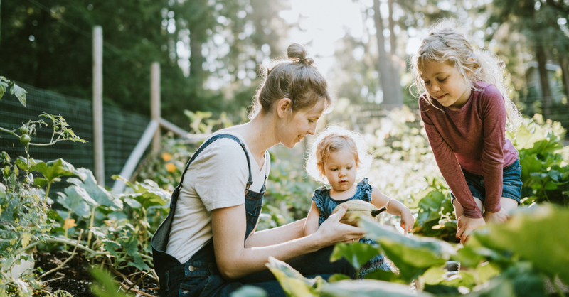 Mom gardening with her two young children.